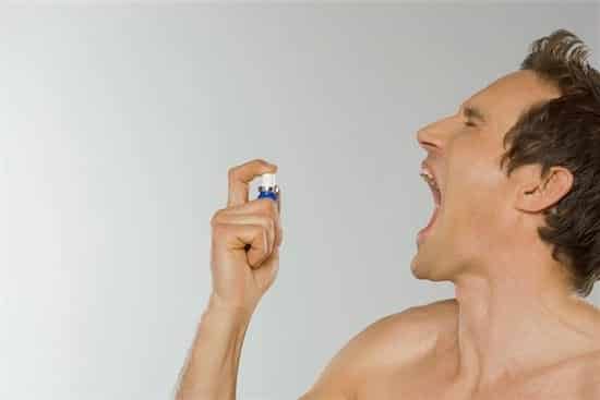 646-02072209 Model Release: Yes Property Release: No Mid adult man spraying breath freshener