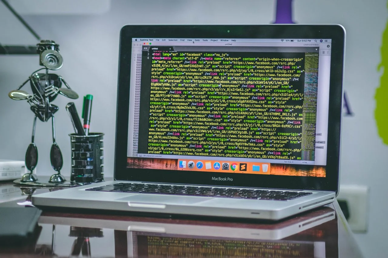 Tela de macbook pro ligado com linhas de código de programação na tela
